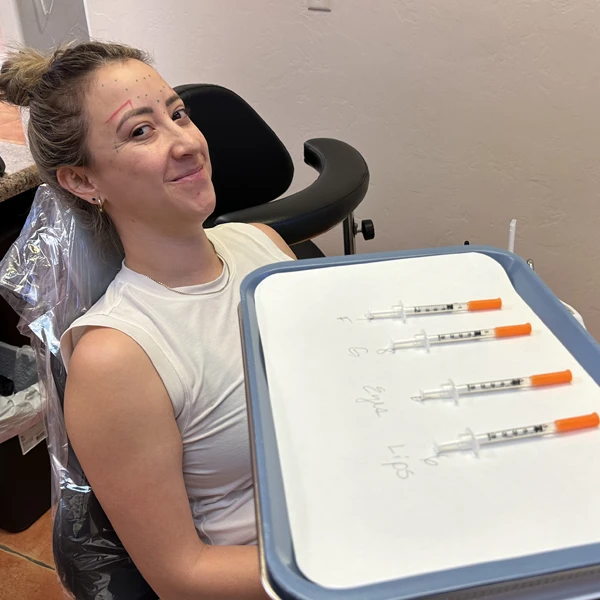 A female botox patient smiling while waiting for her treatment