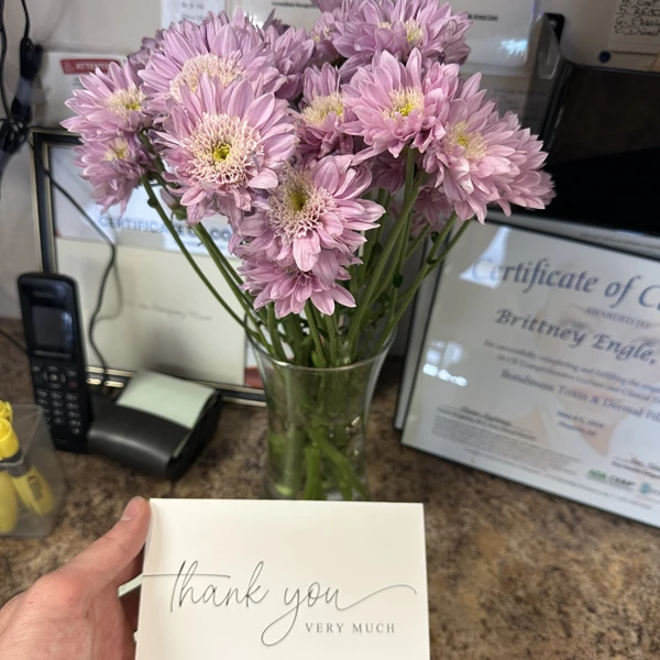 A bouquet of flowers and a thank you card