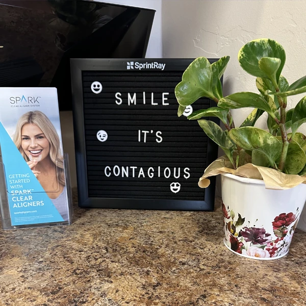 A sign reading "Smile It's Contagious"